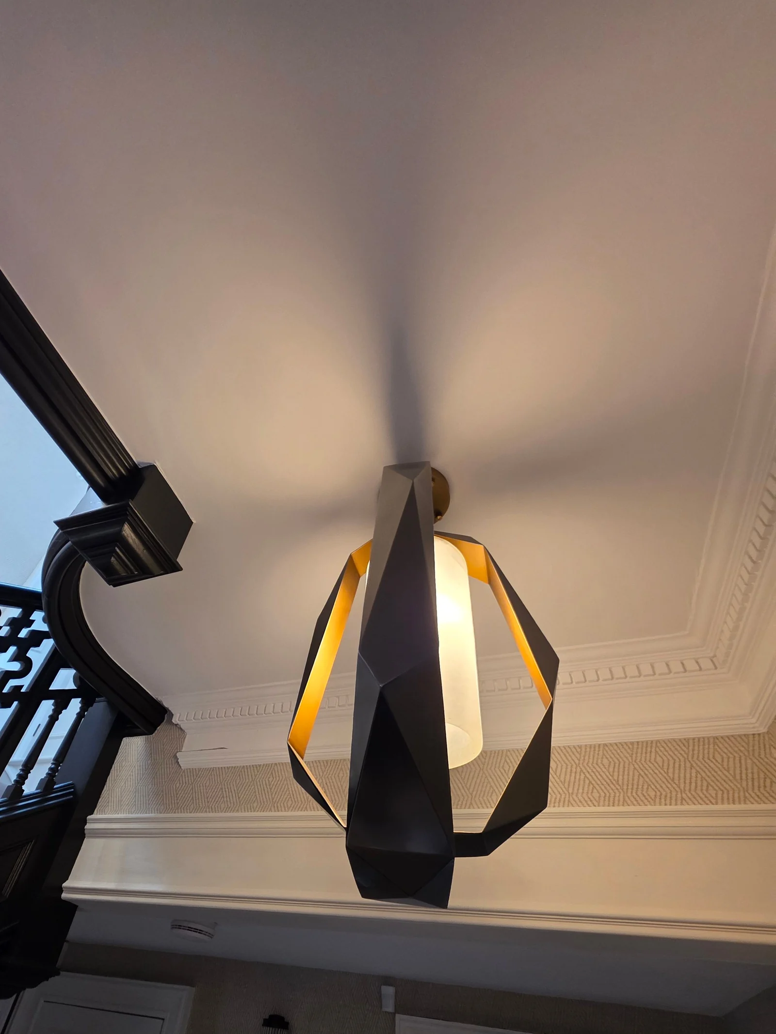 Geometric pendant light installed above a staircase landing by Spartan Electrical